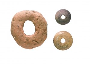 Left- Anglo-Saxon clay loomweight. Right - Stone and bone spindle whorls - both discovered on A14C2H (c) Highways England courtesy of MOLA Headland