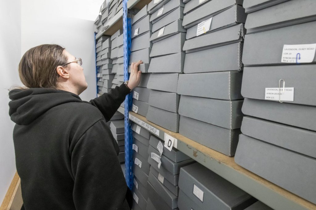 A person looking at boxes in an archive
