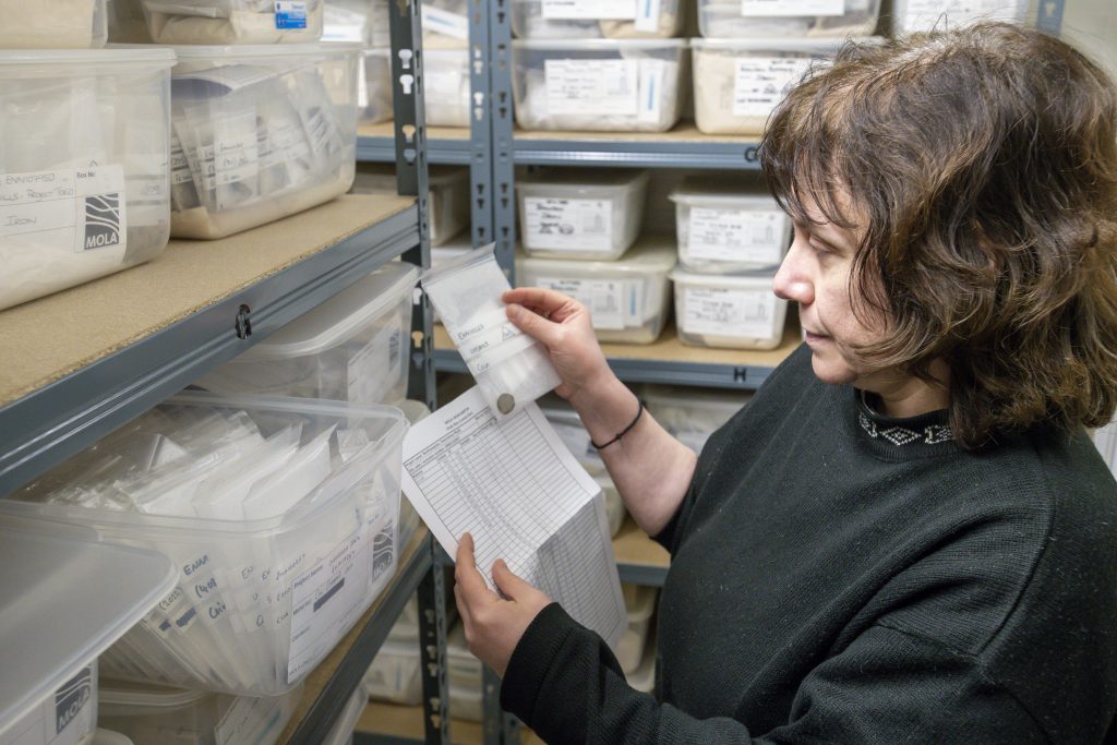 Member of the archives team makes final checks on the boxed artefacts before deposition.