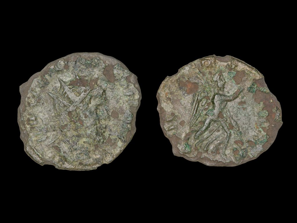 the front and back of a worn Roman coin photographed on a dark background